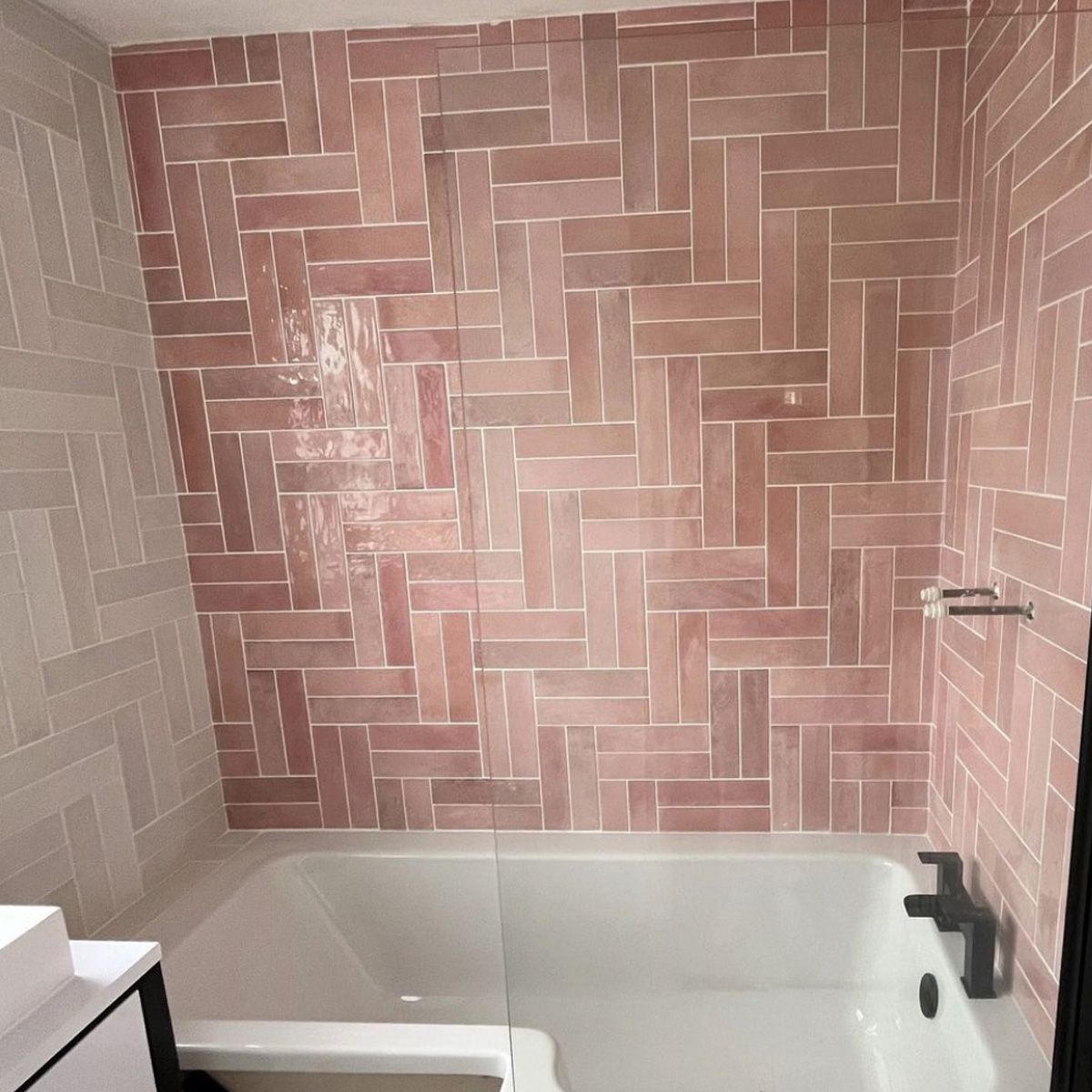 Pink brick wall tiles in a double herringbone pattern in a small bathroom