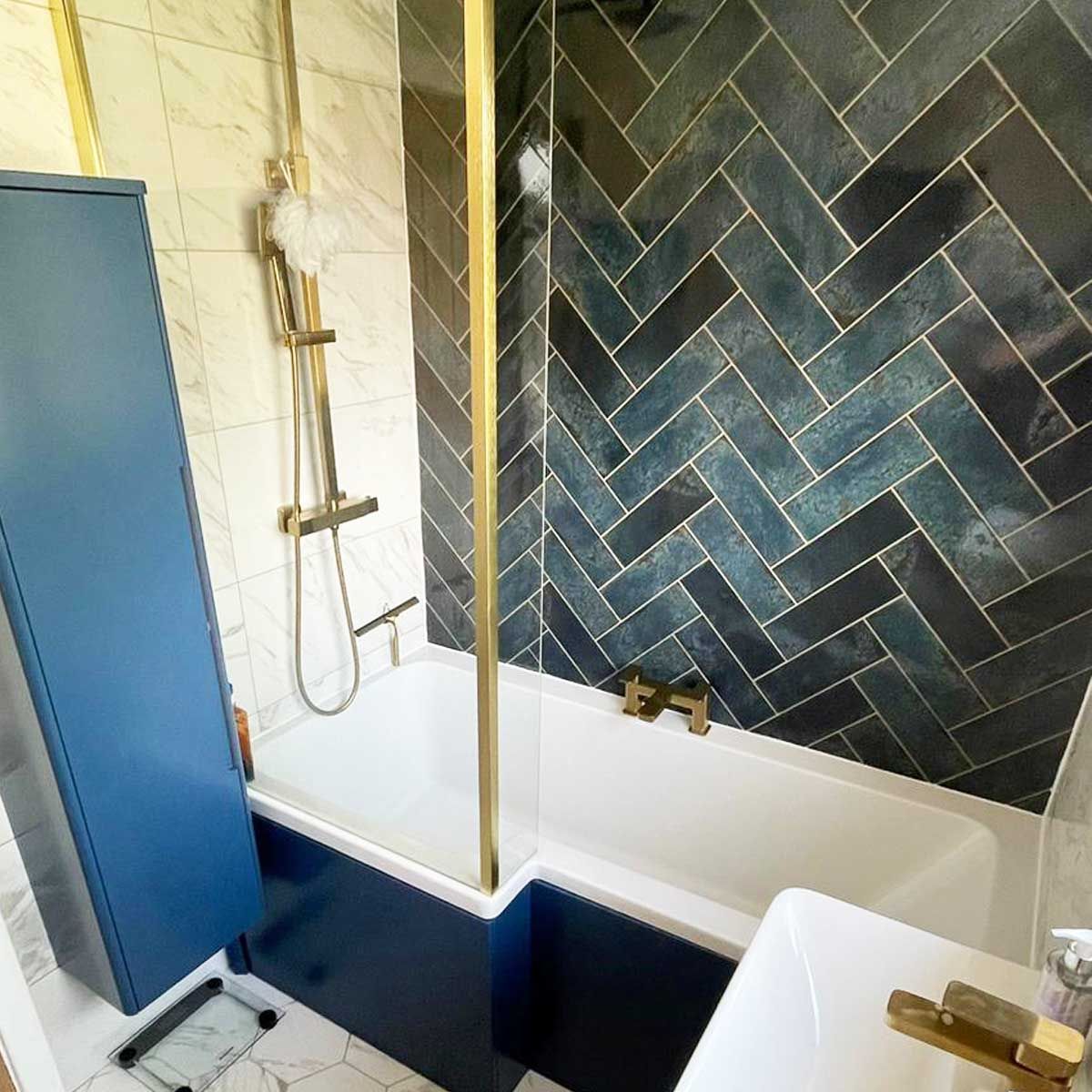 Deep blue wall tiles in a herringbone pattern in a small bathroom